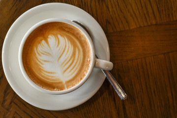 ็High angle view, Coffee latte art on wooden table.