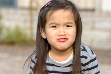 Cute little girl pulling a funny face at camera