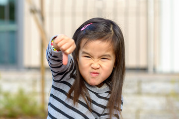 Angry little Asian girl punching at the camera