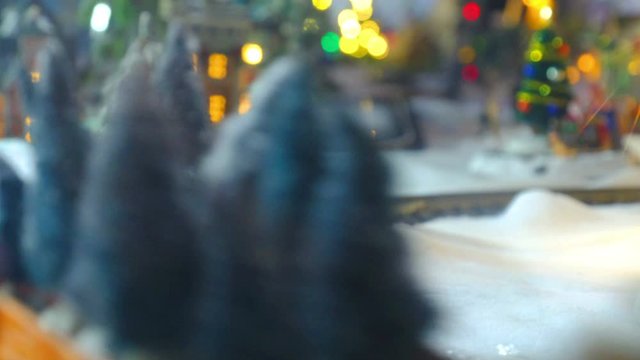 toy train model christmas close up tracks on the snow with town village lights on background