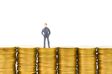 Figure miniature businessman or small people standing on the top stack of coin on white background for money and financial business concept.