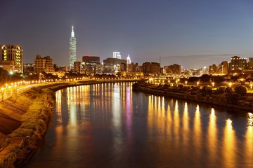 Beautiful riverside scenery of busy Taipei City with view Taipei landmark Tower,  Keelung River and downtown area at dusk ~ A Blue and Gloomy evening in Taipei