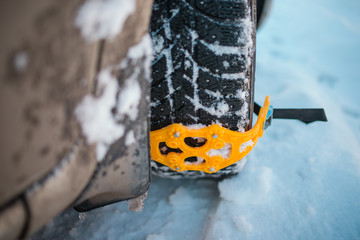 Spikes on wheels. On the snow wheel of the car, yellow anti-skid chains are installed. dangerous...
