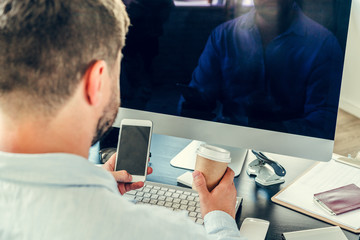 Young man businessman sitting at his working table in office