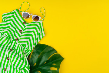 Trendy woman outfit with accessories on bright yellow background