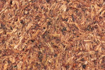 The texture of a chipboard close-up (macro), the dark fonn of compressed sawdust.