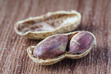 Peanut also known as ground nut with its shell over brown background.
