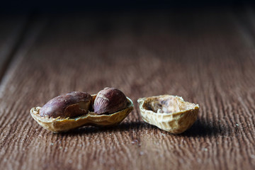 Peanut also known as ground nut with its shell over brown background.