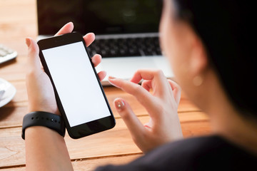 Cropped shot view of man hands holding smart phone with blank copy space screen for your text message or information content, female reading text message on cell telephone during in urban setting. 