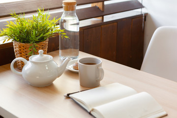 Cup of hot black tea close up on wooden table