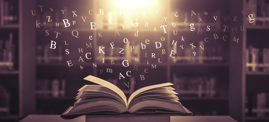 Imagine opening an old book blurred with magic power on the table and the English alphabet floating above the book with magic light as a beautiful background design.