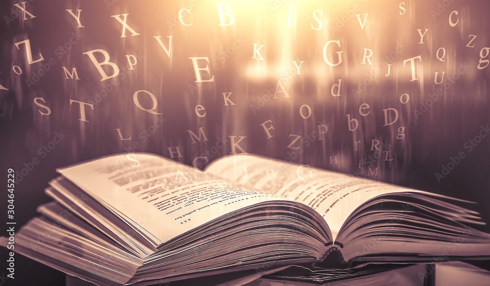 Poster imagine opening an old book blurred with magic power on the table and the english alphabet floating 