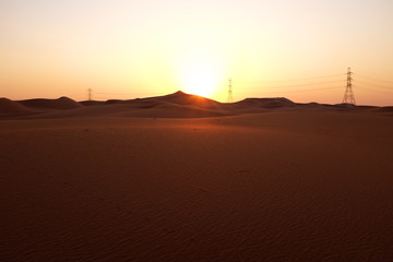 Power transmission towers in a desert near Riyadh, Saudi Arabia at sunrise. Power and Energy Industry
