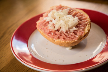 Teller  Mettbrötchen mit Mett und Zwiebeln auf Holz Tisch