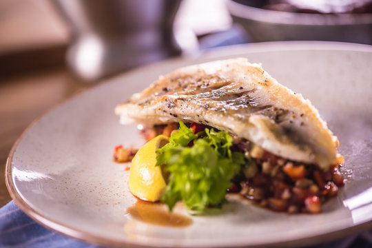 Fillet of zander with vegetables on a plate in a restaurant