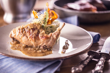 Rabbit leg with mashes potatoes and decoration on plate in restaurant