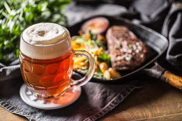 Glass of red beer in pub or restavurant on table with delicoius food