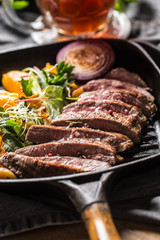 Beef flank steak in grill pan with batata puree garlic herb decoration and draft beer