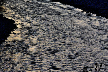 Silhouette of a river of Provence, flows between stones and pebbles. Silver colored.