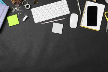 Flat lay composition with keyboard, smartphone and stationery on black background, space for text....