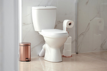 Modern toilet bowl with roll of paper in bathroom - obrazy, fototapety, plakaty