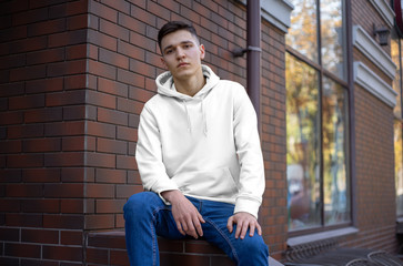 Template of a white hoodie on a young guy, front view.
