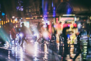 crowd of people walking on night street in the city 