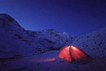 Outdoor red camping tent in Switzerland snow mountain