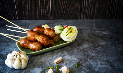 Thai sausage with fresh vegetables and peppers on a concrete background