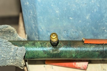 an old and rusty leaking pipe of air conditioning unite fixed into AC heavy duty compressor