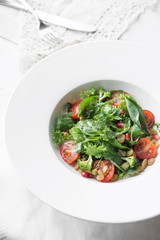 Homemade green broccoli salad with grapes, onion and tomato