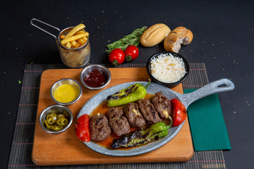 Homemade roasted beef meatballs in cast-iron skillet on wooden table in kitchen, fresh parsley, vintage fork, top view