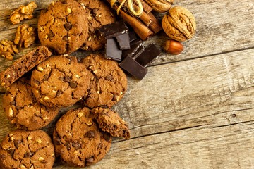 Homemade chocolate cookies with nuts on wooden table. Sweet food for coffee. Unhealthy food. Risk of obesity.