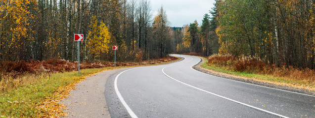 panorama winding asphalt road through the autumn forest without cars
