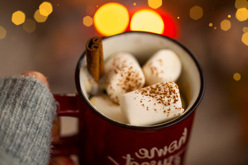 Hot chocolate cup with marshmallows candies and cinnamon spice