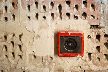 EU power outlet type C, electric point of power at home, on a red brick background with holes