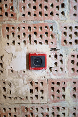 EU power outlet type C, electric point of power at home, on a red brick background with holes