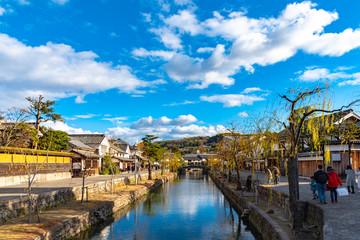 View of Kurashiki Bikan Historical Quarter. Townscape known for characteristically Japanese white walls of residences and willow trees lining banks of Kurashiki River, Okayama, Japan