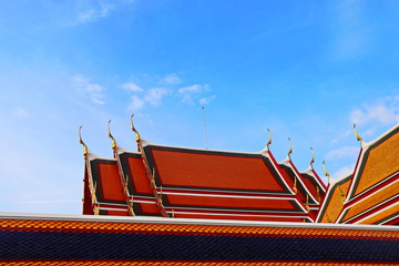 beautiful Thai temple tile roof contrast with blue sky