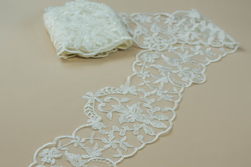 Texture lace fabric. lace on white background studio. thin fabric made of yarn or thread. a background image of ivory-colored lace cloth. White lace on beige background.