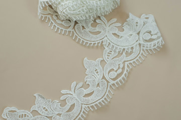 Texture lace fabric. lace on white background studio. thin fabric made of yarn or thread. a background image of ivory-colored lace cloth. White lace on beige background.