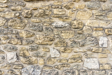 Rough surface of random pattern rastic of brown and light yellow color natural free form sand stone cladding on the concrete wall background