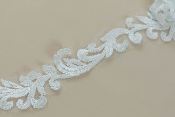 Texture lace fabric. lace on white background studio. thin fabric made of yarn or thread. a background image of ivory-colored lace cloth. White lace on beige background.