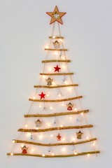 Christmas creative decoration - homemade wooden hanging christmas tree on the wall
