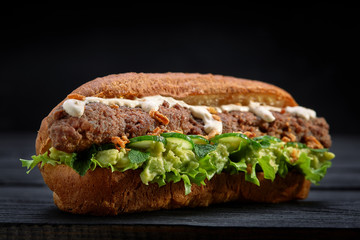 close up of kebab sandwich on black wooden background