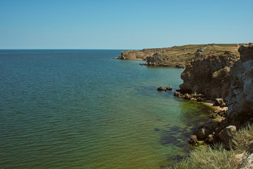 Scenic view of the rugged coastline. Sea coast with high cliffs. Peaked rocks on the seashore