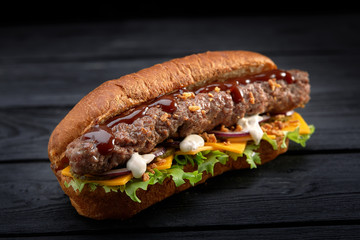 close up of kebab sandwich on black wooden background
