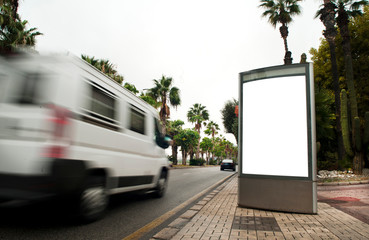 White blank vertical billboard at the bus stop on the city street. In the background of van and roads. Sketch. Poster on the street next to the road