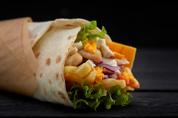 Tasty doner kebabs with fresh salad trimmings and shaved roasted meat served in tortilla wraps on...