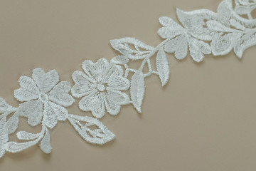 Texture lace fabric. lace on white background studio. thin fabric made of yarn or thread. a background image of ivory-colored lace cloth. White lace on beige background.